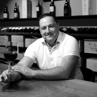 Pedro Ferreira am Tisch mit einem Glas Rotwein - Vinothek Denz Weine Zürich
