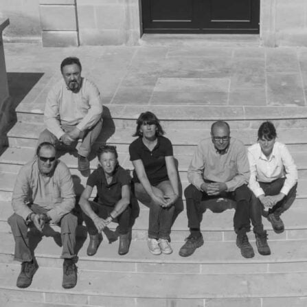 Das Team von Chateau La Tour Figeac sitzt auf einer Treppe